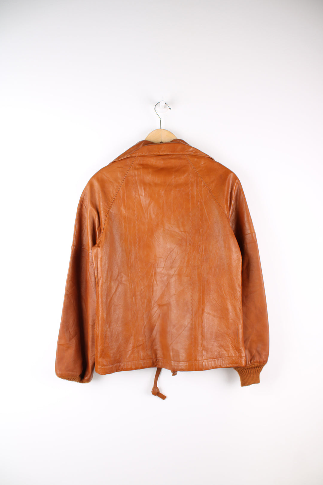 Vintage 1970's orange/tan zip through leather jacket, by Imperial. Features dagger collar, and drawstring waist 