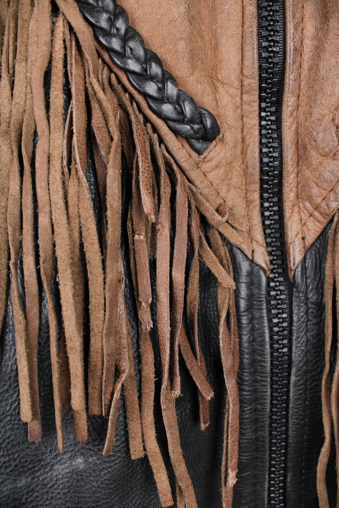 Vintage 80's black and brown fringe motorcycle leather jacket. Features a cropped fit,  fringe detailing on the sleeves and across the back of the shoulder 