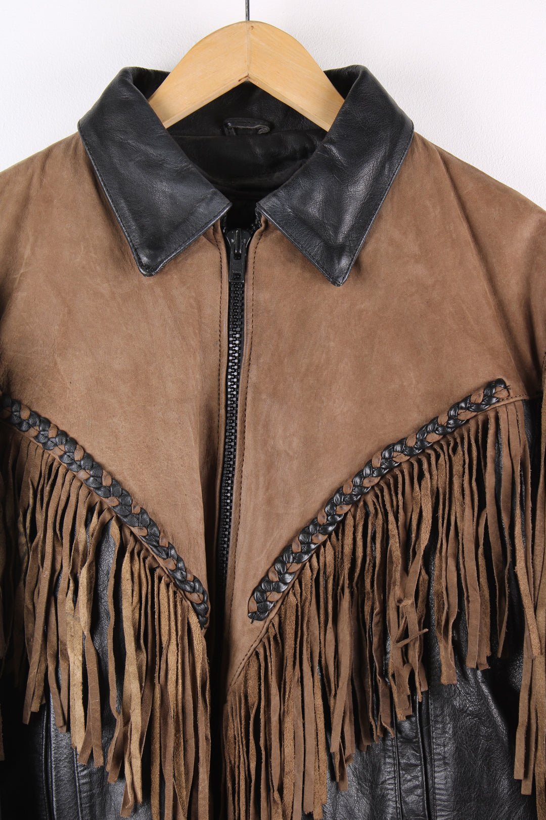 Vintage 80's black and brown fringe motorcycle leather jacket. Features a cropped fit, removable liner and fringe detailing on the sleeves and across the back of the shoulder