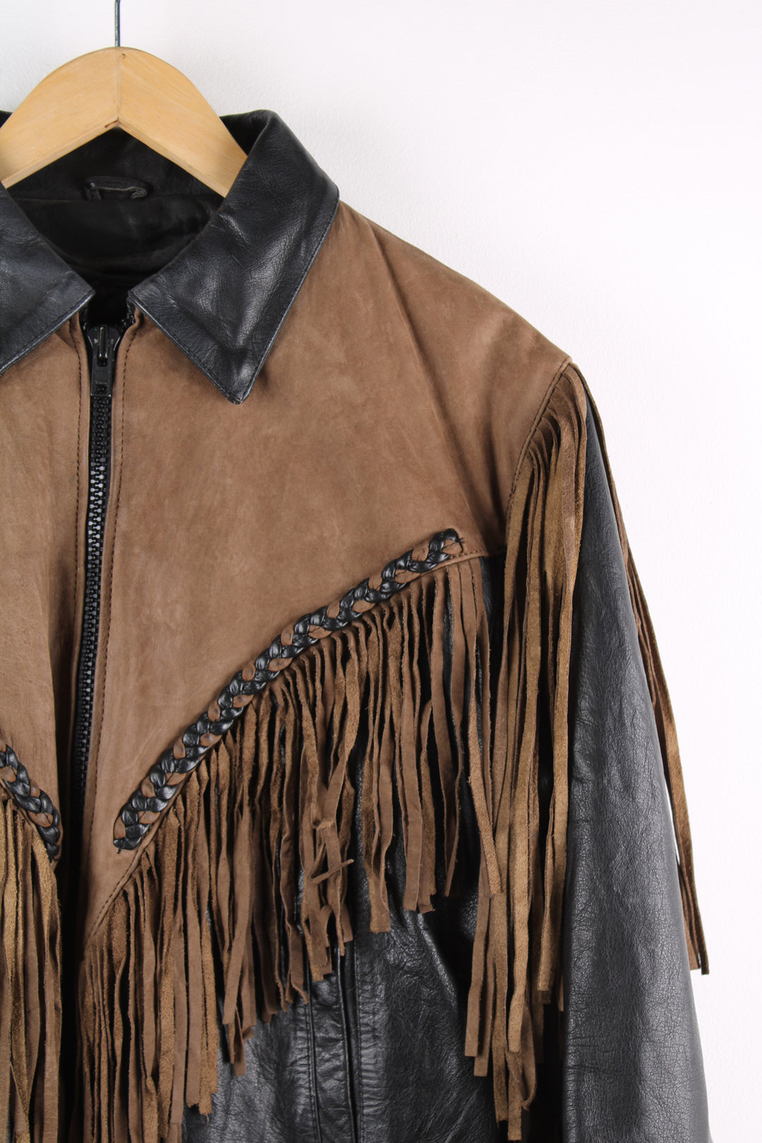 Vintage 80's black and brown fringe motorcycle leather jacket. Features a cropped fit, removable liner and fringe detailing on the sleeves and across the back of the shoulder