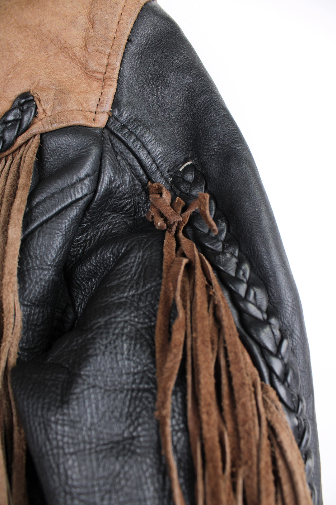 Vintage 80's black and brown fringe motorcycle leather jacket. Features a cropped fit,  fringe detailing on the sleeves and across the back of the shoulder 