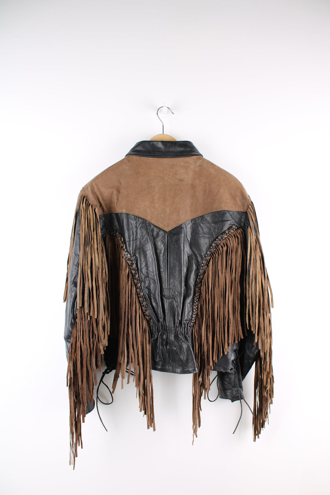 Vintage 80's black and brown fringe motorcycle leather jacket. Features a cropped fit, removable liner and fringe detailing on the sleeves and across the back of the shoulder