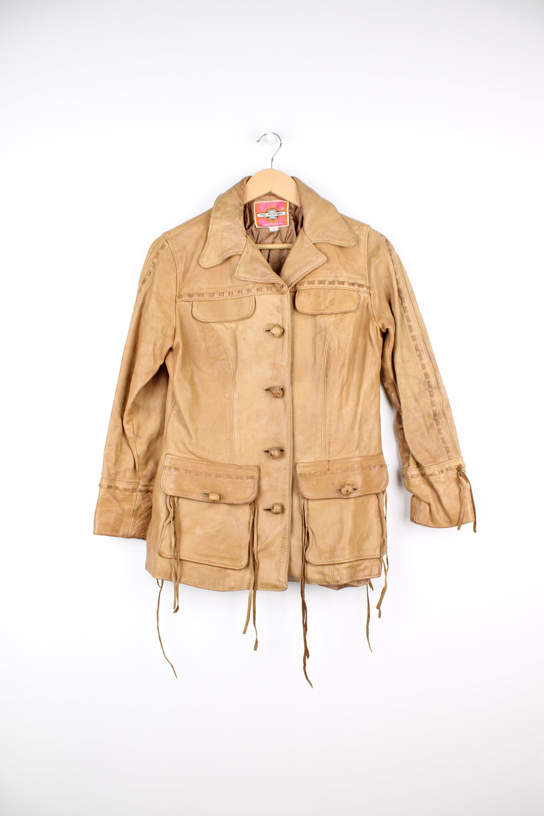 Vintage made in Albuquerque smooth tan leather jacket with fringe details on the pockets, raised stitched detailing on the sleeves and pockets and leather toggle buttons 