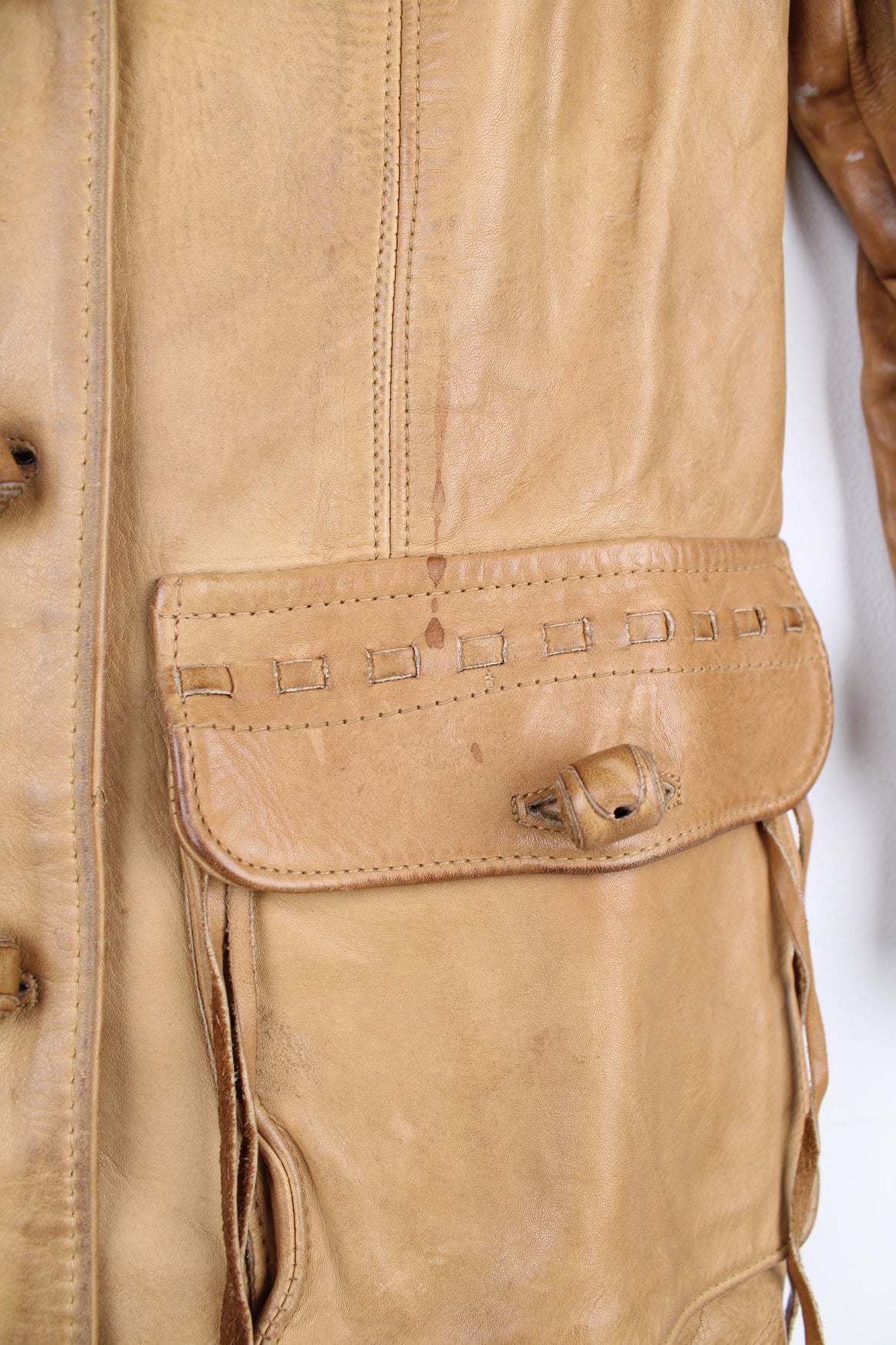 Vintage made in Albuquerque smooth tan leather jacket with fringe details on the pockets, raised stitched detailing on the sleeves and pockets and leather toggle buttons 