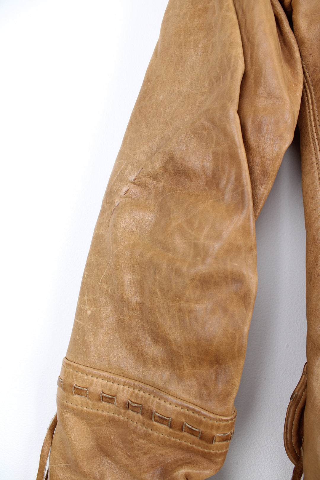 Vintage made in Albuquerque smooth tan leather jacket with fringe details on the pockets, raised stitched detailing on the sleeves and pockets and leather toggle buttons 