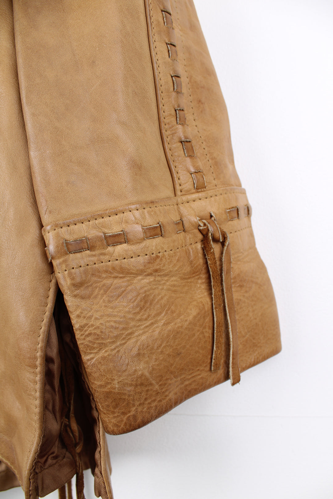 Vintage made in Albuquerque smooth tan leather jacket with fringe details on the pockets, raised stitched detailing on the sleeves and pockets and leather toggle buttons 