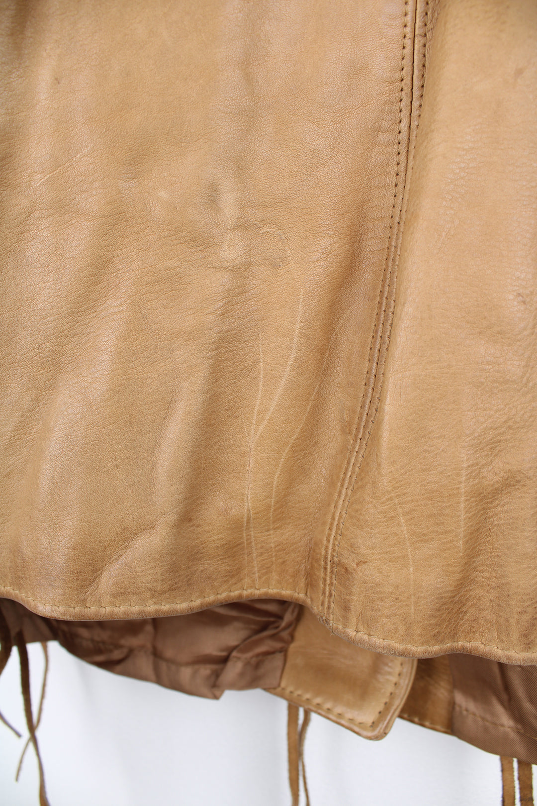 Vintage made in Albuquerque smooth tan leather jacket with fringe details on the pockets, raised stitched detailing on the sleeves and pockets and leather toggle buttons 