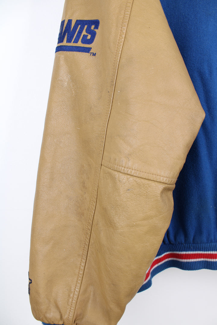 90's New York Giants varsity jacket with blue wool body and tan leather arms. Features embroidered logos on the arms and felt applique logo across the chest  good condition - Discoloration around the collar and scuffs to the leather on the arms and bobbling through out (see photos) Size in Label: Mens XL 