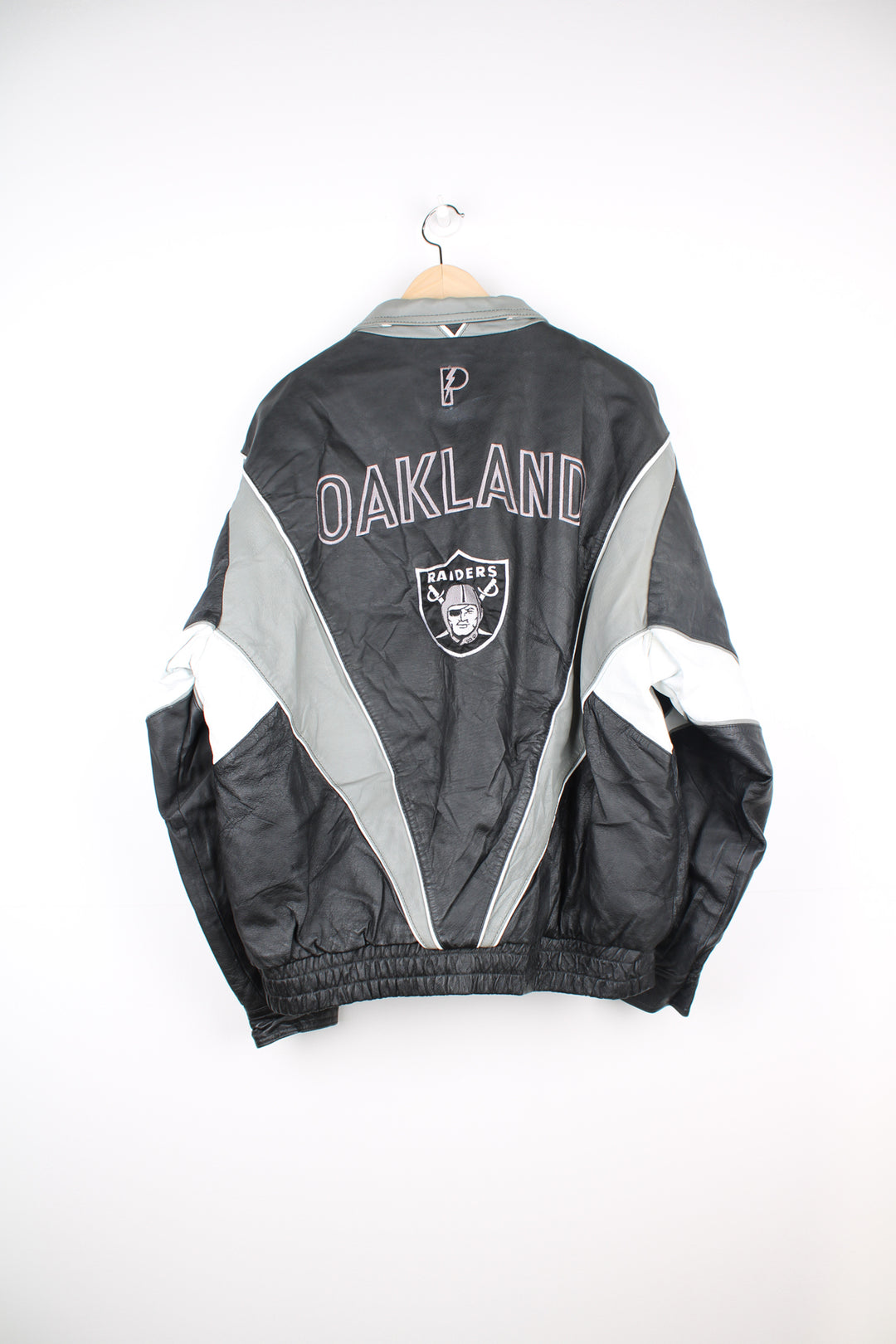 90's Oakland (now Las Vegas) Raiders Leather leather varsity style bomber jacket with embroidered Raiders patch on the chest and back. Made by Pro Player by Daniel Young. good condition - light discoloration and scratches to the white parts of the leather (see photos)