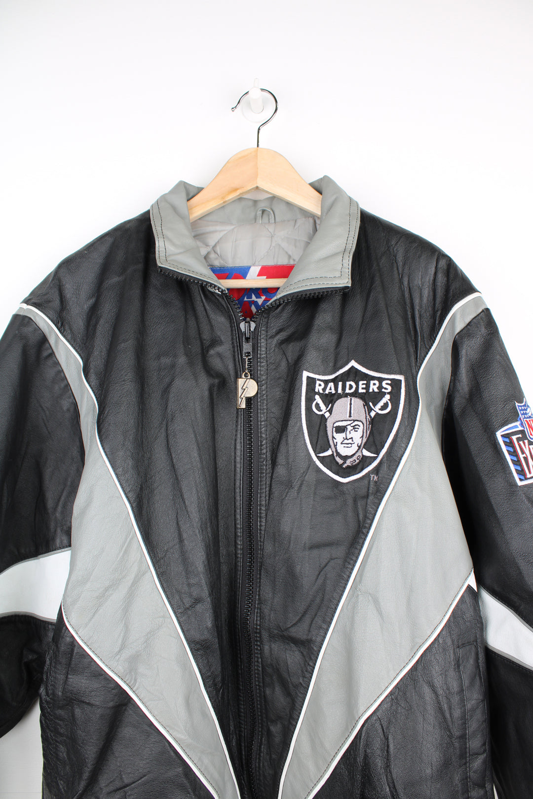 90's Oakland (now Las Vegas) Raiders Leather leather varsity style bomber jacket with embroidered Raiders patch on the chest and back. Made by Pro Player by Daniel Young. good condition - light discoloration and scratches to the white parts of the leather (see photos)