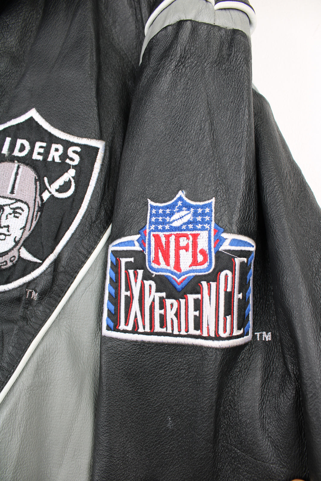 90's Oakland (now Las Vegas) Raiders Leather leather varsity style bomber jacket with embroidered Raiders patch on the chest and back. Made by Pro Player by Daniel Young. good condition - light discoloration and scratches to the white parts of the leather (see photos)