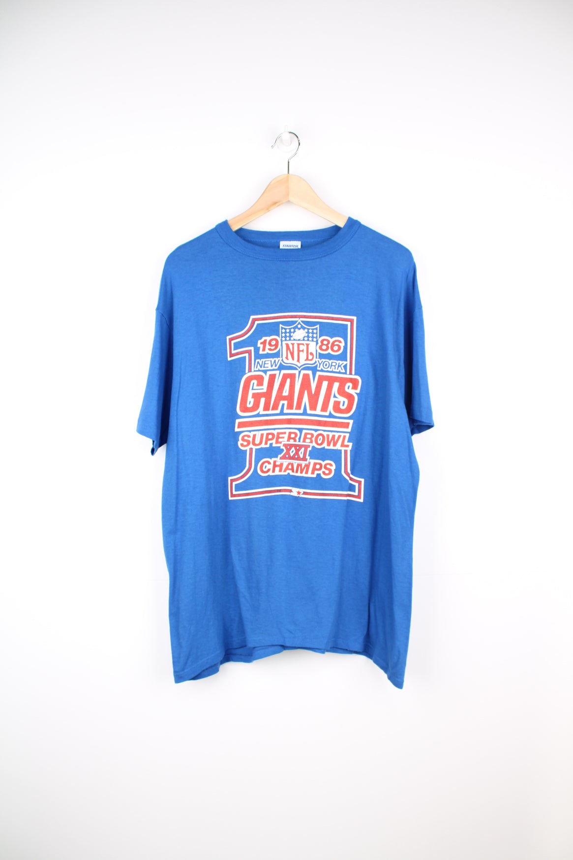 Vintage 1986 New York Giants Superbowl XXI Champion blue t-shirt made by Starter. Features printed graphic on the front and single stitch seams on the sleeves. good condition - some small cracks to the graphic (see photos) Size in Label: Mens XL - Measures more like a L