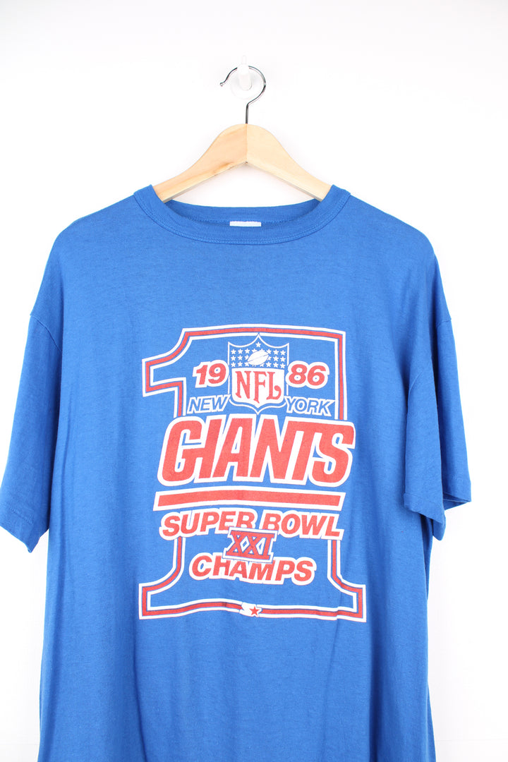 Vintage 1986 New York Giants Superbowl XXI Champion blue t-shirt made by Starter. Features printed graphic on the front and single stitch seams on the sleeves. good condition - some small cracks to the graphic (see photos) Size in Label: Mens XL - Measures more like a L