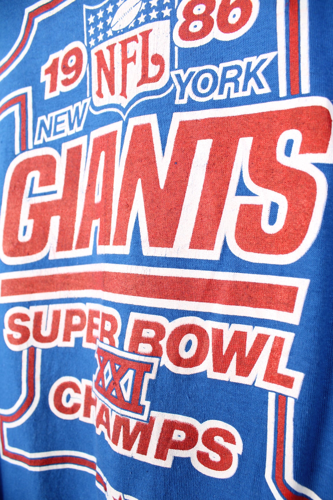 Vintage 1986 New York Giants Superbowl XXI Champion blue t-shirt made by Starter. Features printed graphic on the front and single stitch seams on the sleeves. good condition - some small cracks to the graphic (see photos) Size in Label: Mens XL - Measures more like a L