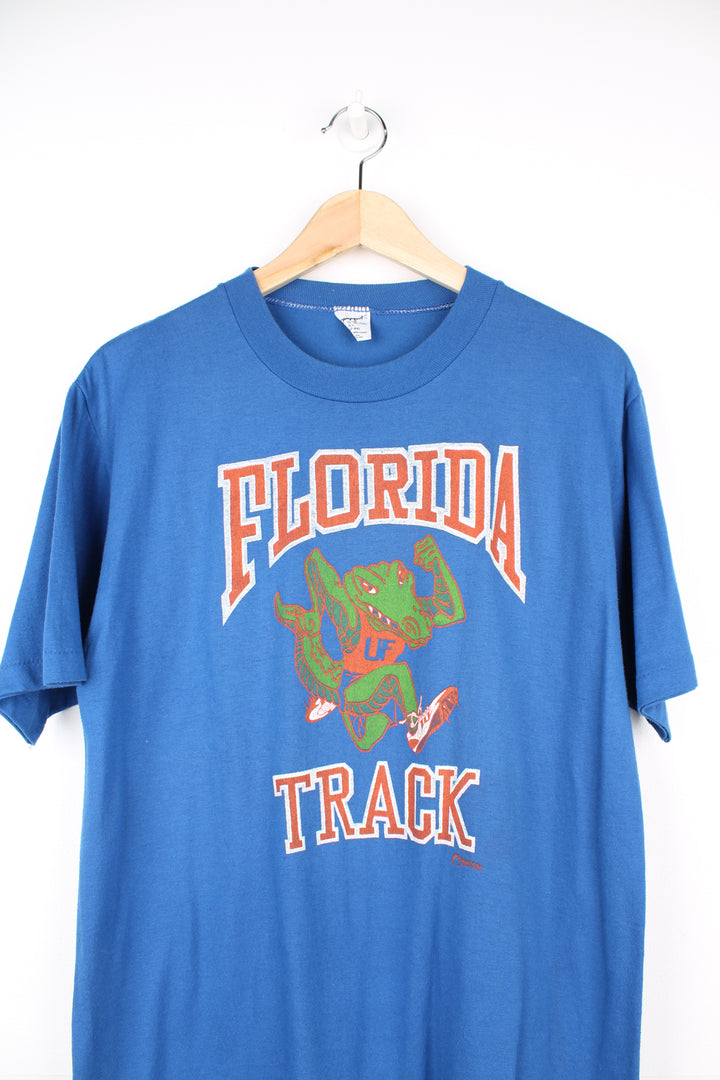 Vintage 80's Florida Track blue t-shirt. Features printed graphic on the front and single stitch seams on the sleeves. good condition - some cracks to the graphic (see photos) Size in Label:  Mens L - Measures more like a M 