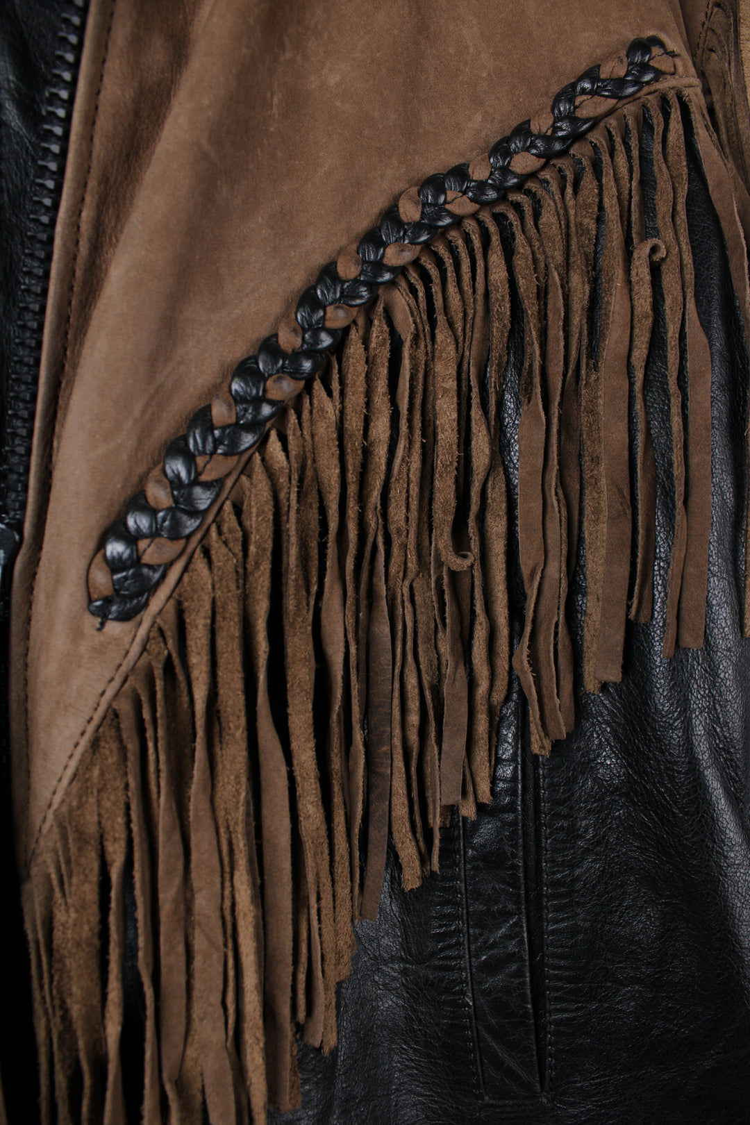 Vintage 80's black and brown fringe motorcycle leather jacket. Features a cropped fit, removable liner and fringe detailing on the sleeves and across the back of the shoulder