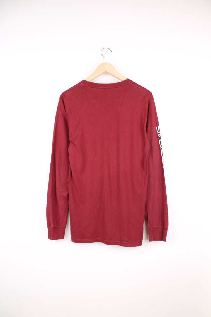 Maroon red Stussy long sleeved t-shirt with yin yang graphic on the front and spell-out graphic down the sleeve 