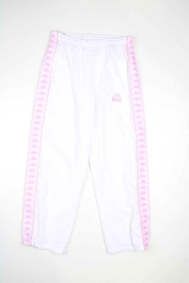 Vintage Kappa tracksuit bottoms in a white colourway with pink logo going down the sides, elasticated waist, and has logo embroidered on the front.