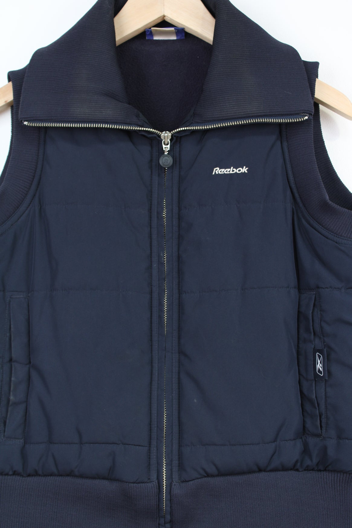 Reebok navy blue zip through puffer gilet, with pockets and embroidered logo on chest