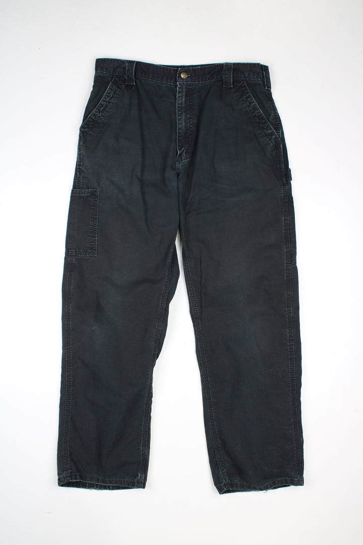 Black Carhartt 100% cotton carpenter trousers with multiple pockets and signature brown leather logo on the back pocket