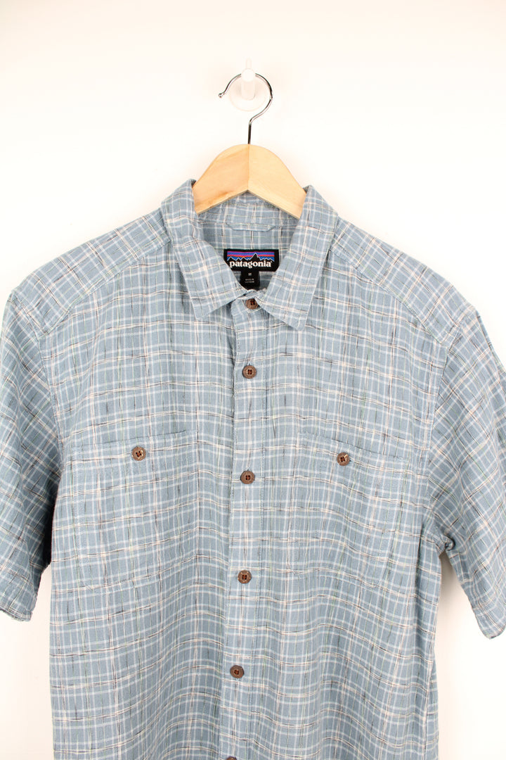 Patagonia Short Sleeve Plaid Shirt in a blue and white colourway, button up, double chest pockets and has the logo embroidered on the side.