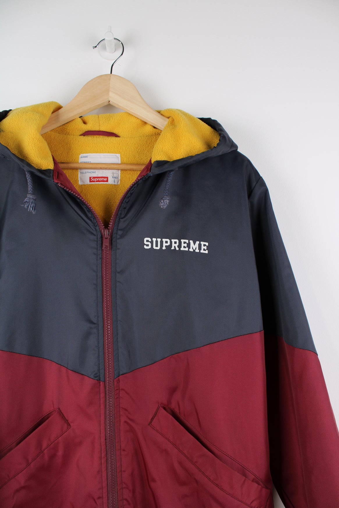 F/W 2012 Supreme Sideline Jacket. Fleece lined bench coat with full zip, hood and Supreme lettering printed on the front and back. good condition - a repair has been made to the seam under the armpit. A name has been written in the name tag. Size in Label: L