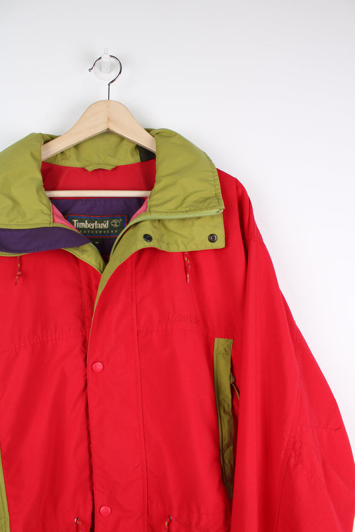 Vintage Timberland Weathergear jacket in a red colourway, zip up, side pockets, hooded and has embroidered logo on the front.