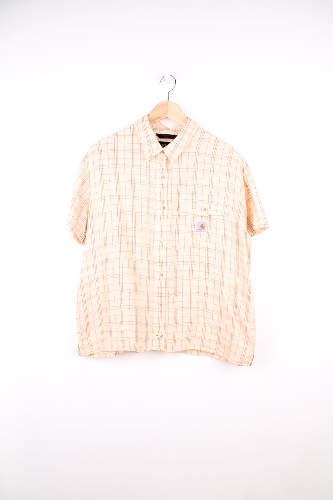 Carhartt Plaid Short Sleeve Shirt in a tan and red colourway, button up, cropped fit, has hidden side pockets, and also has the logo embroidered on the chest pocket.