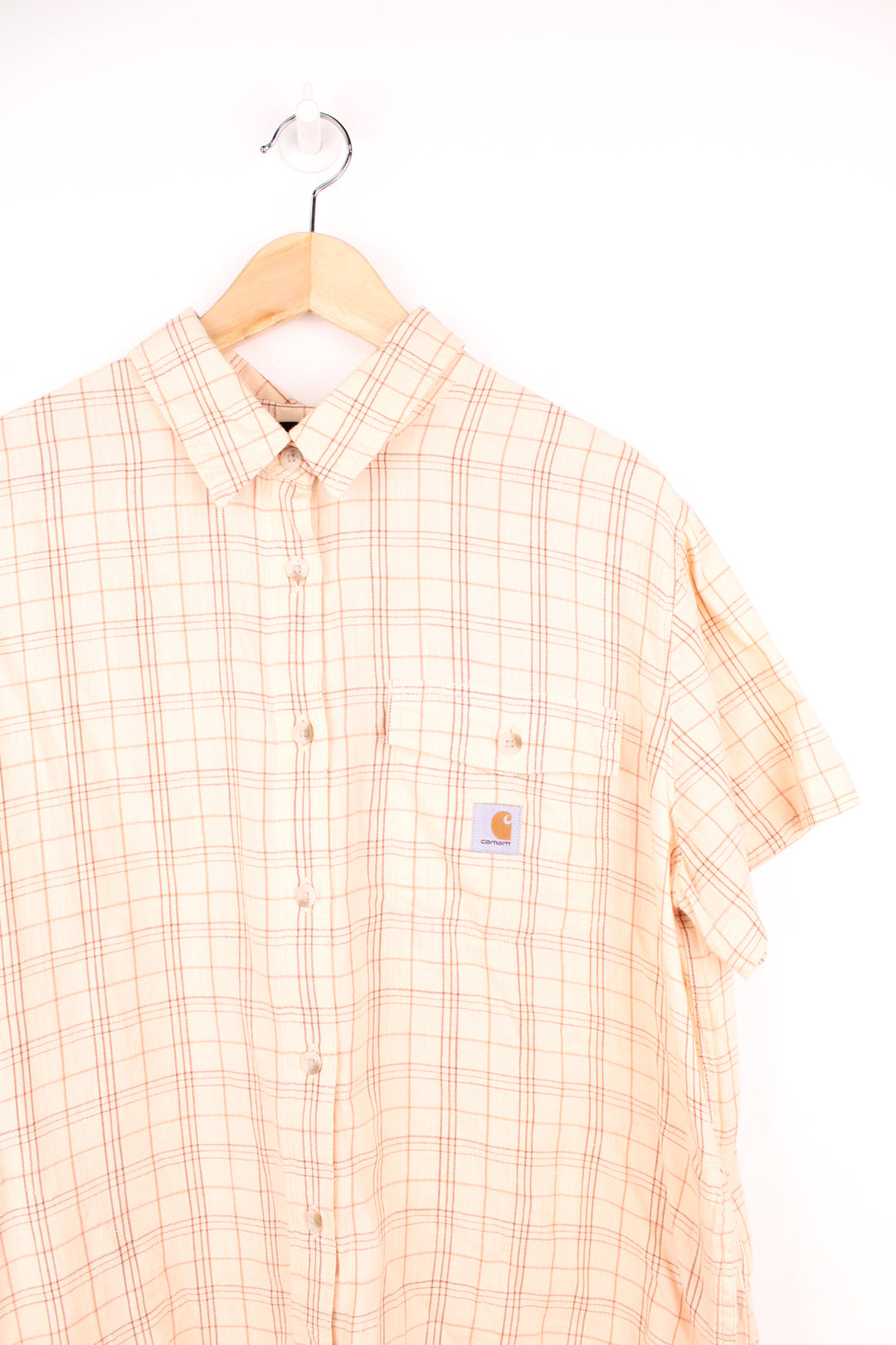 Carhartt Plaid Short Sleeve Shirt in a tan and red colourway, button up, cropped fit, has hidden side pockets, and also has the logo embroidered on the chest pocket.