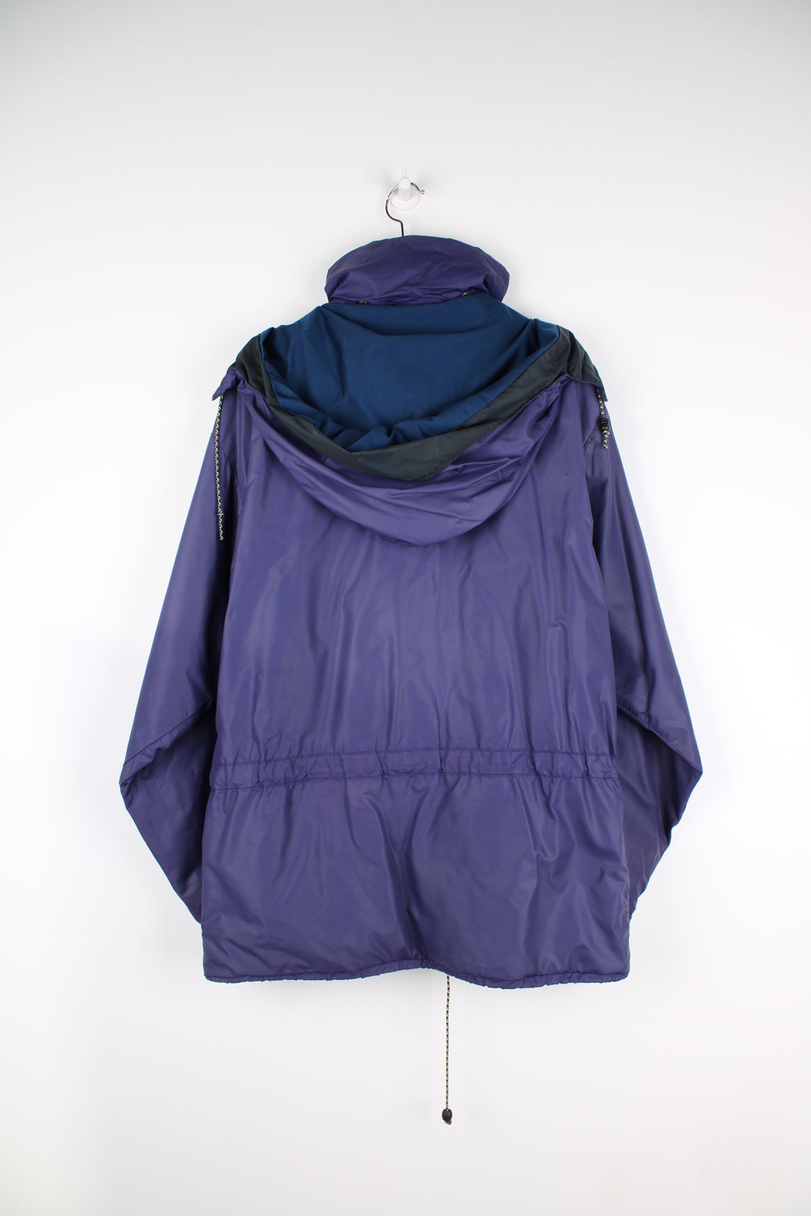 Vintage Rab Downpour waterproof jacket in purple, zip up, multiple pockets, hooded and has logo embroidered on the front.