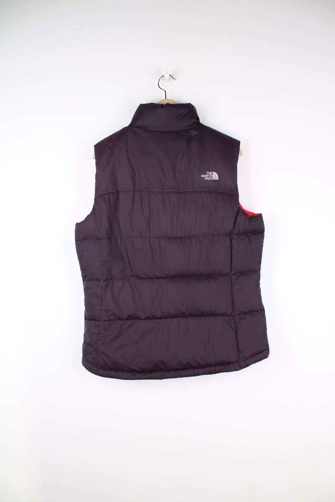 The North Face Gilet in a purple and pink colourway, zip up, insulated, and has logo embroidered on the front and back.