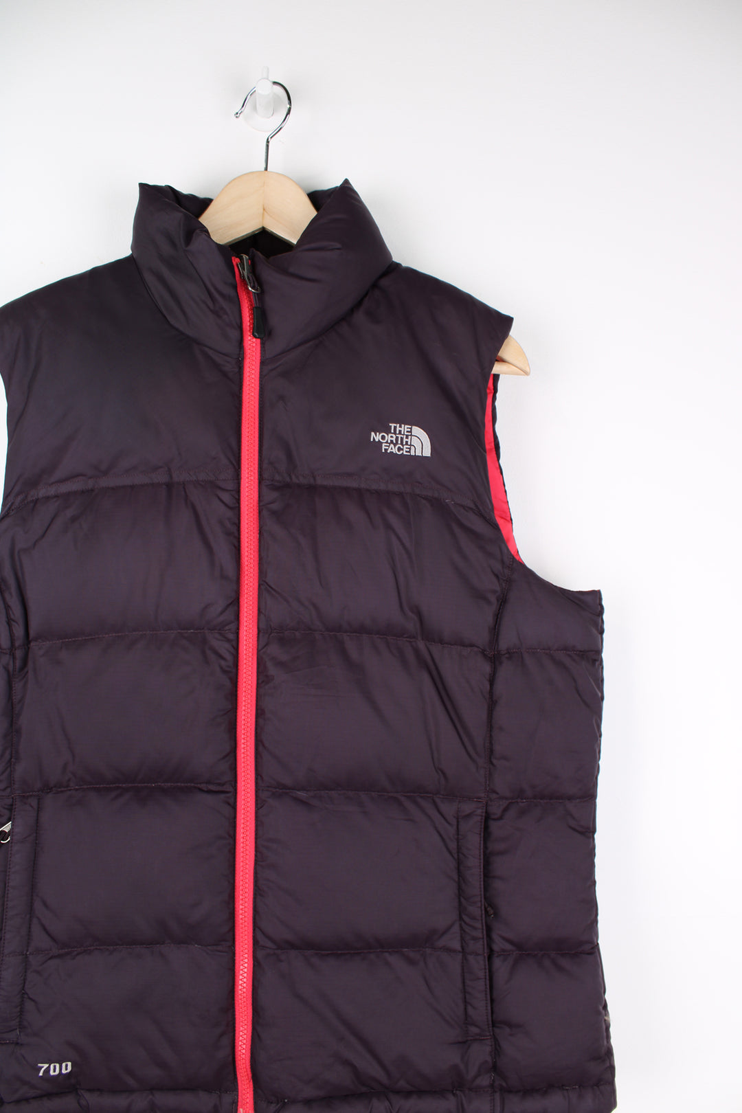 The North Face Gilet in a purple and pink colourway, zip up, insulated, and has logo embroidered on the front and back.