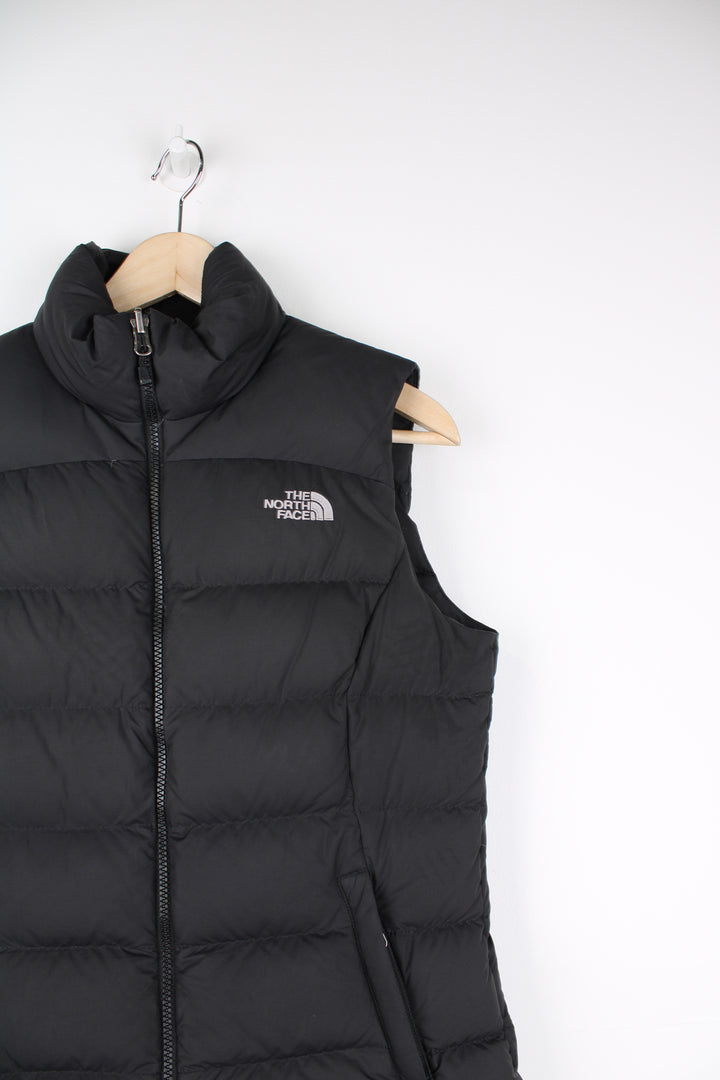 The North Face Face puffer gilet in black, zip up with side pockets, insulated and has logo embroidered logo on the front and back.