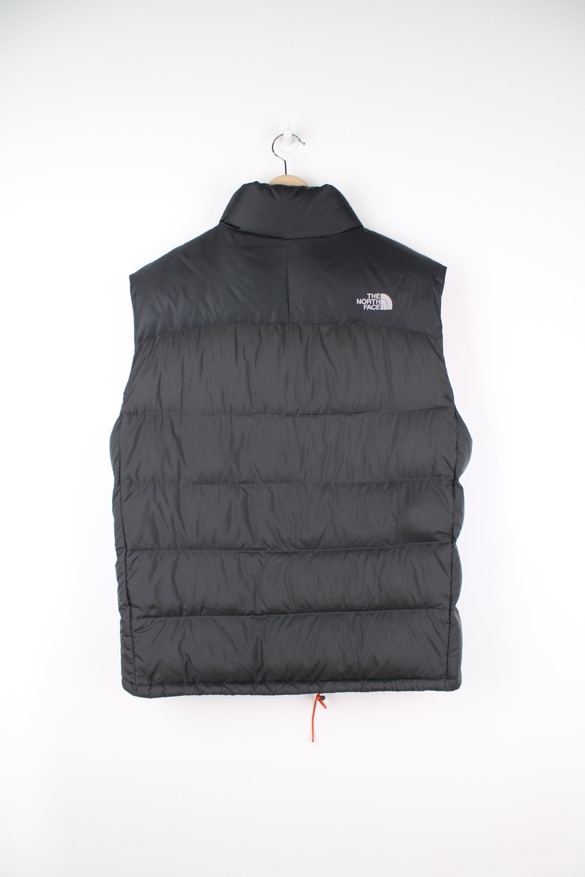 The North Face Face puffer gilet in a grey and orange, zip up with side pockets, insulated and has logo embroidered logo on the front and back.