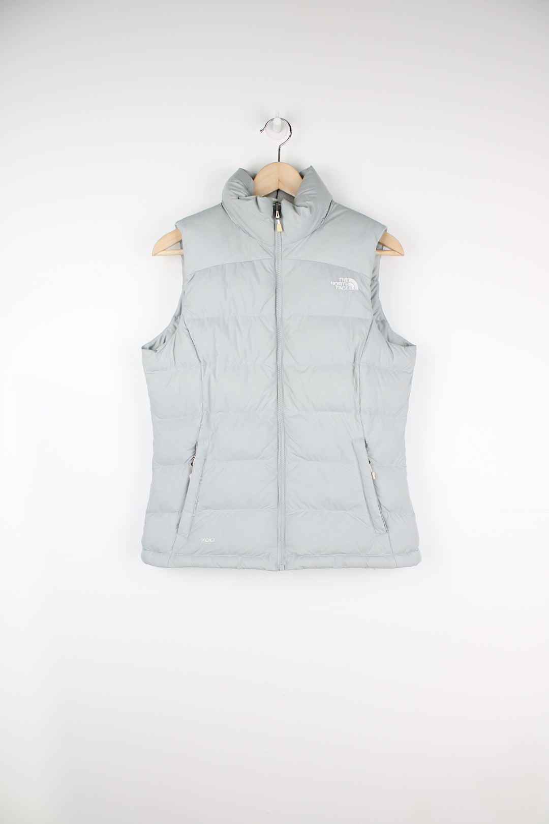 The North Face Face puffer gilet in a grey, zip up with side pockets, insulated and has logo embroidered logo on the front and back.