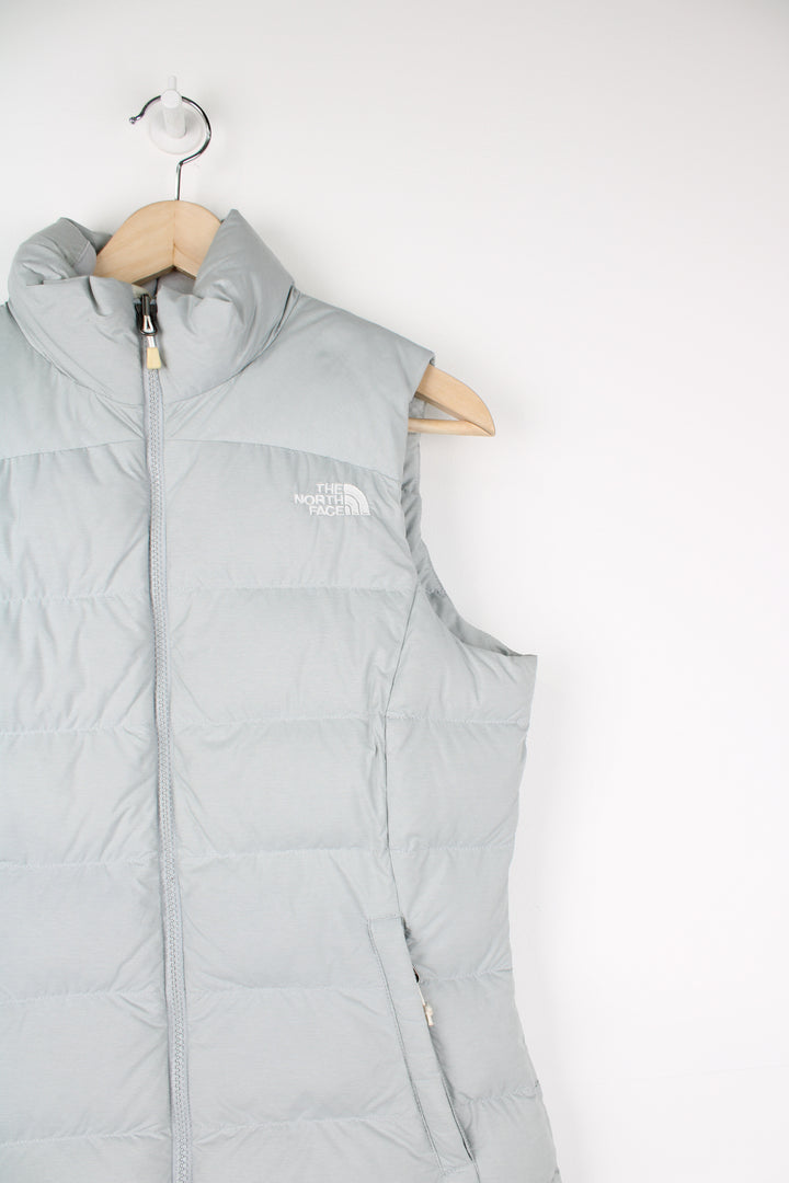 The North Face Face puffer gilet in a grey, zip up with side pockets, insulated and has logo embroidered logo on the front and back.