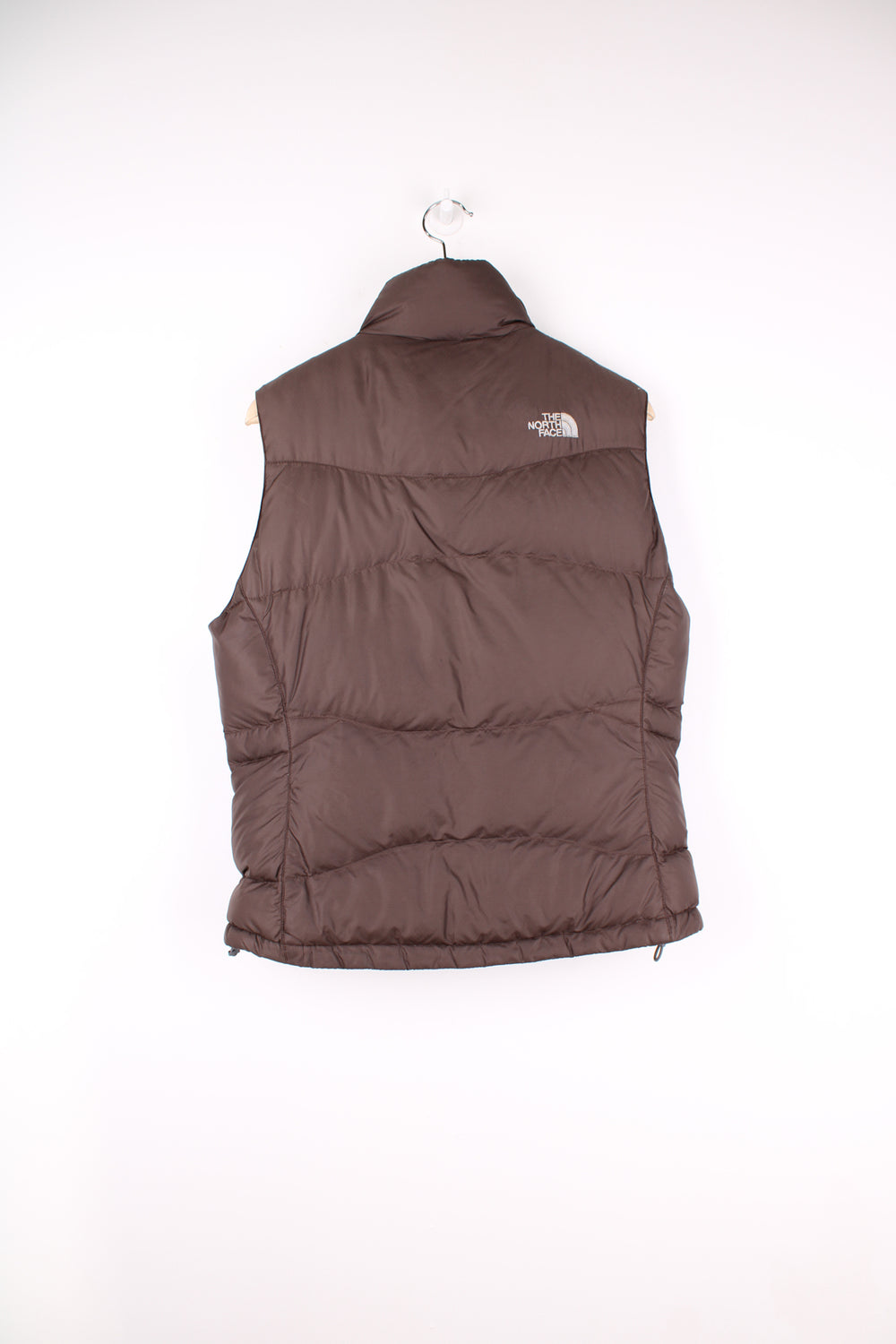 The North Face Face puffer gilet in brown, zip up with side pockets, insulated and has logo embroidered logo on the front and back.