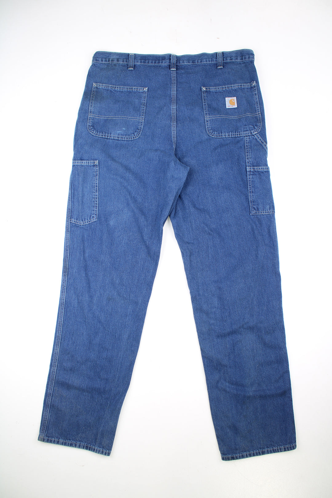 Carhartt Carpenter Jeans in a blue colourway with white cross stitching throughout, multiple pockets, and has the logo embroidered on the back pocket.