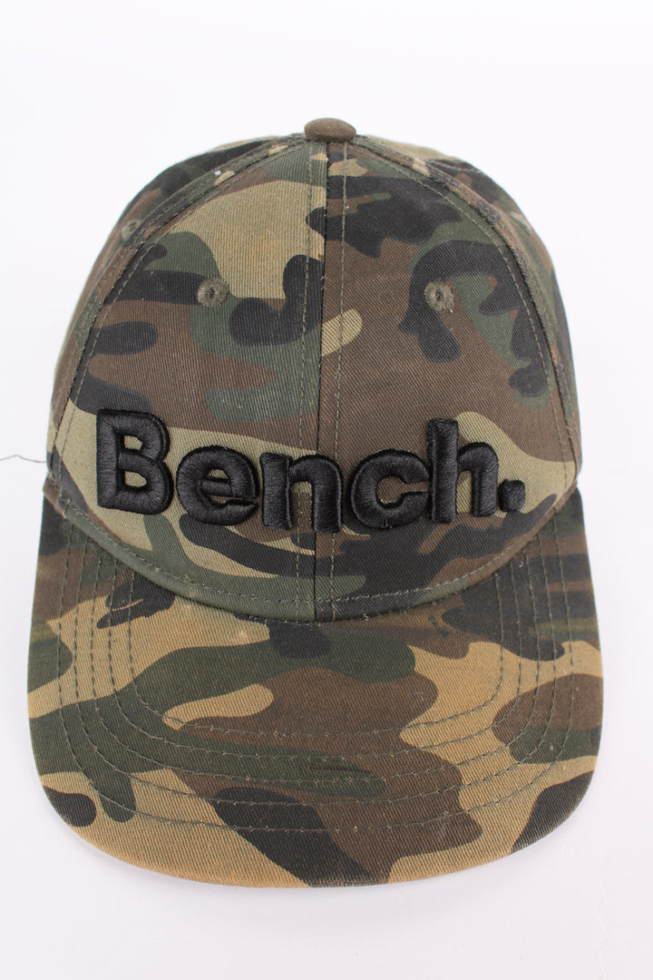 Y2K Bench camouflage baseball cap features embroidered spell-out logo across the front and adjustable velcro strap 