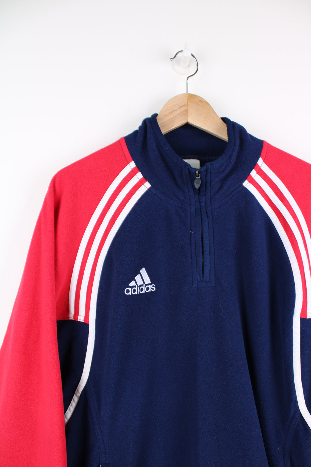 Adidas Fleece in a blue, white and red colourway, quarter zip up, side pockets, adjustable waist and has the logo embroidered on the front and back.