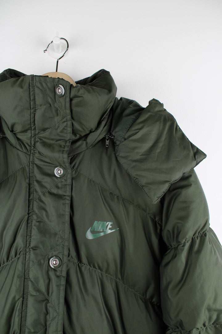 Vintage Nike puffer jacket in green, insulated, detachable hood, zip and button up, has logo printed on the front.