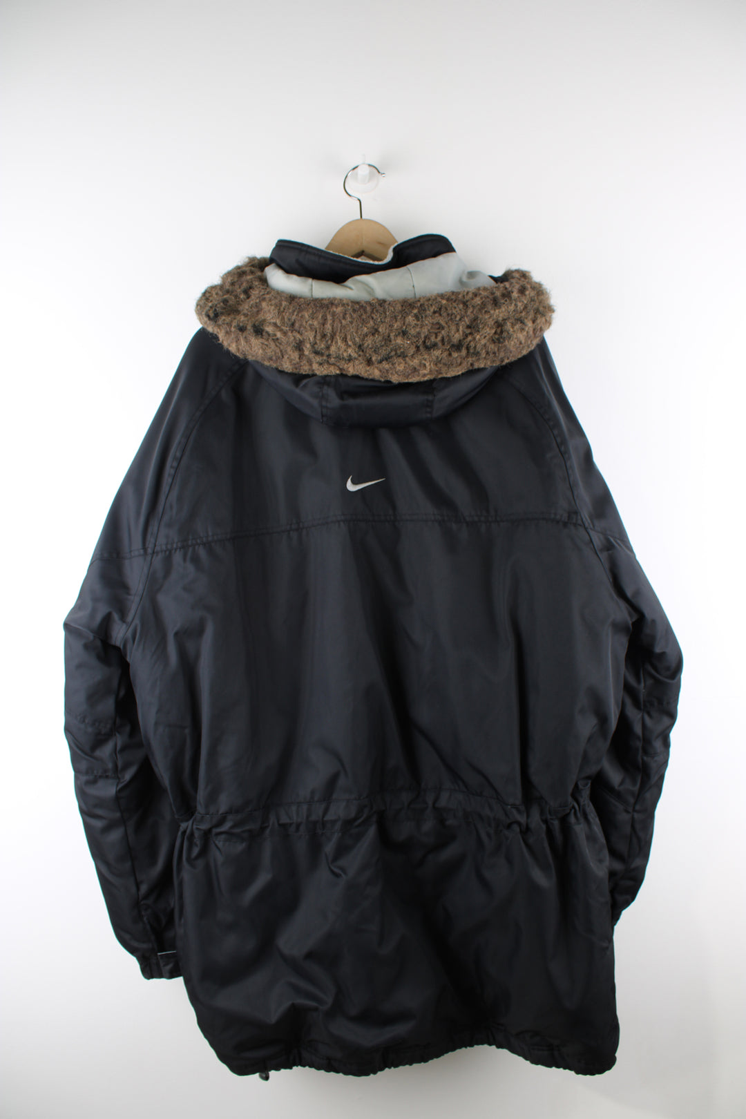 Vintage Nike Parka Coat in black, zip up, multiple pockets, detachable hood, fleece lining, and has swoosh logo embroidered on the front and back. 