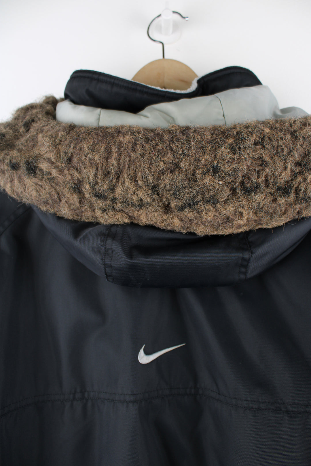 Vintage Nike Parka Coat in black, zip up, multiple pockets, detachable hood, fleece lining, and has swoosh logo embroidered on the front and back. 