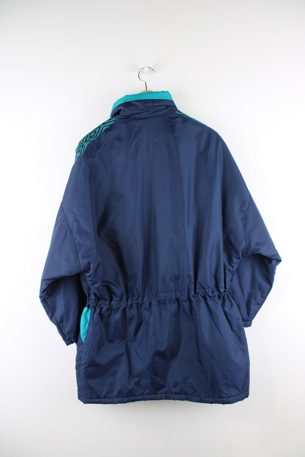 Vintage Umbro sports coats in a blue and green colourway, zip up, multiple pockets, insulated, has a hidden hood, adjustable and has logo embroidered on the front.