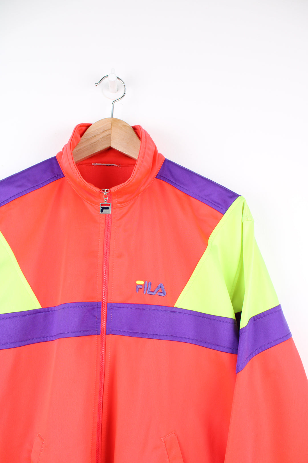 Fila Tracksuit Jacket in a neon orange, green and purple colourway, zip up, side pockets, and has the logo embroidered on the front.