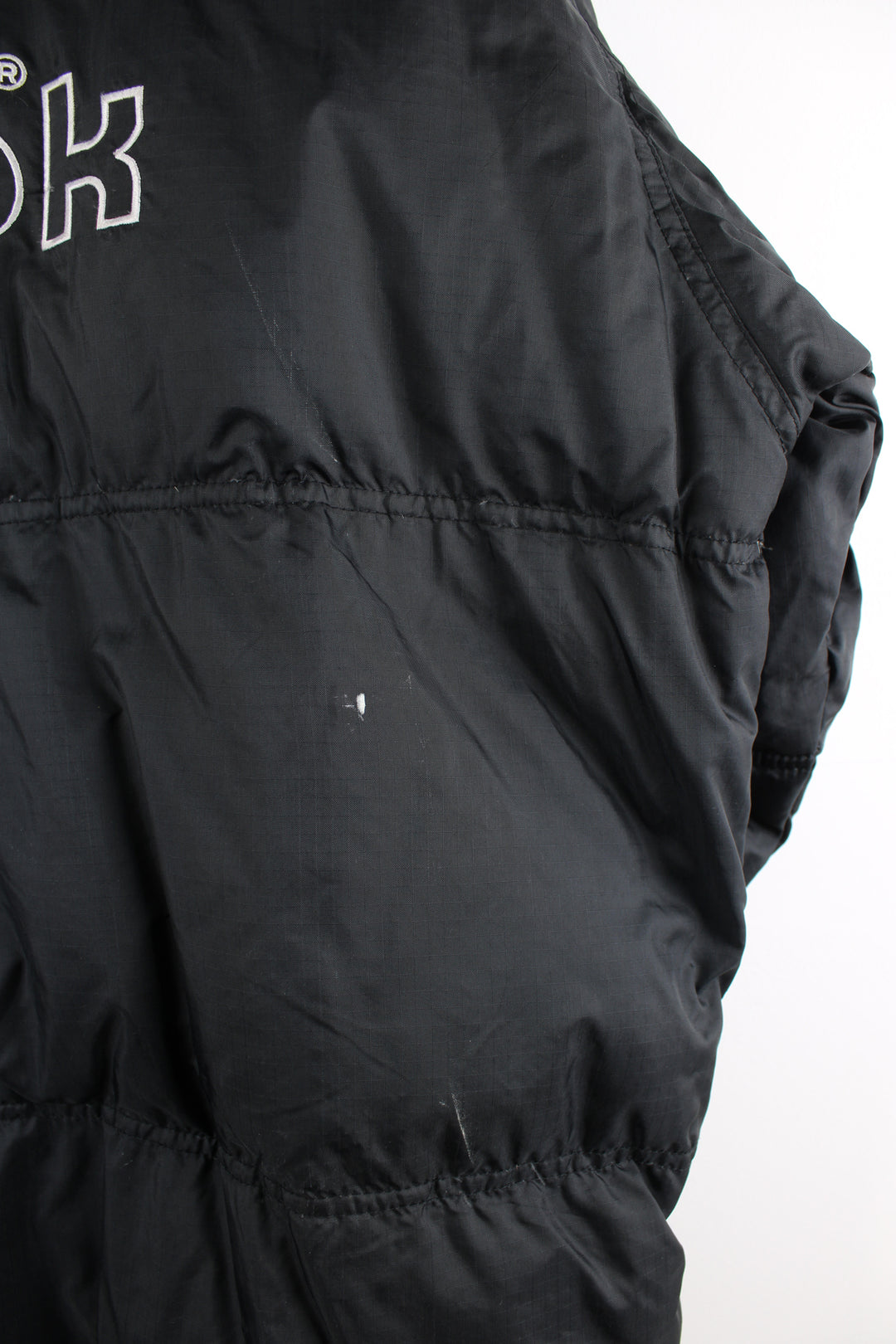 Vintage Reebok puffer jacket in black, zip up, insulated, side pockets and has the logo spell-out embroidered on the front and back.