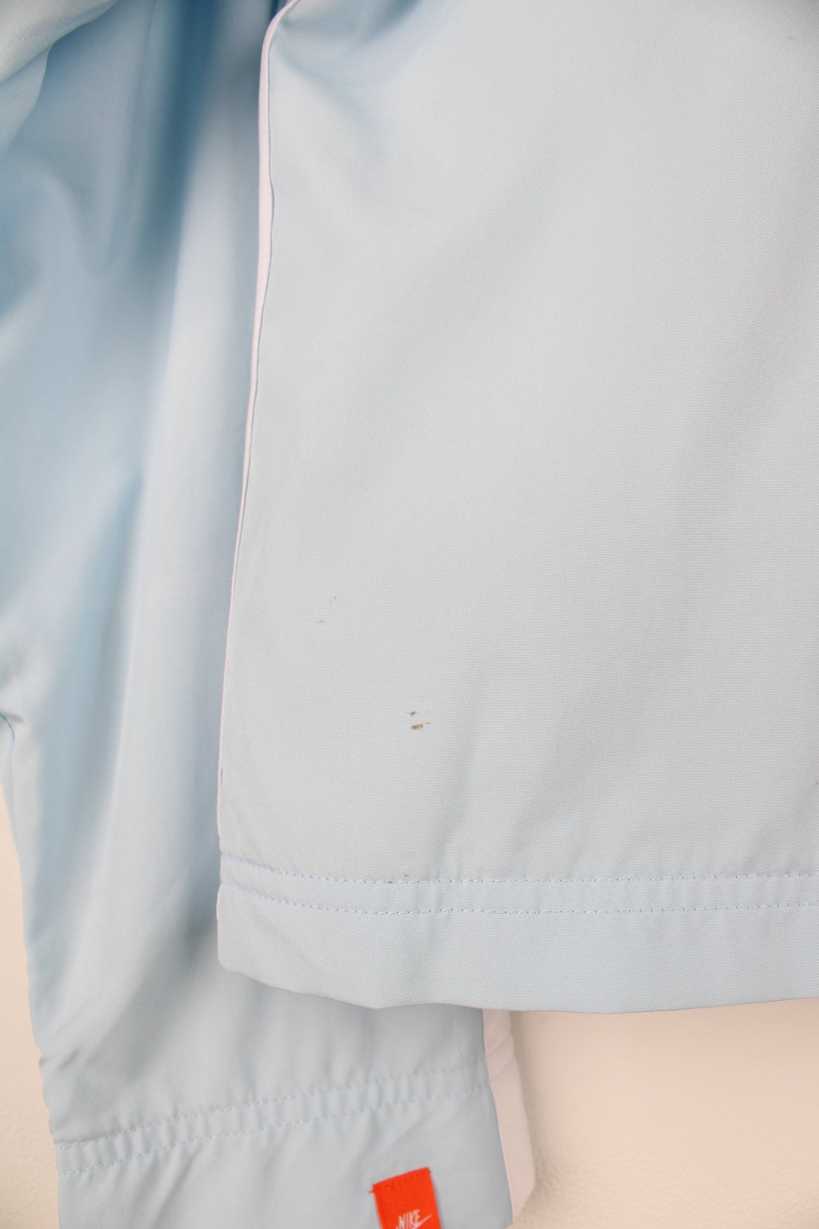 Nike Tracksuit Jacket in a blue and white colourway, zip up, side pockets, and has the swoosh logo embroidered on the front.