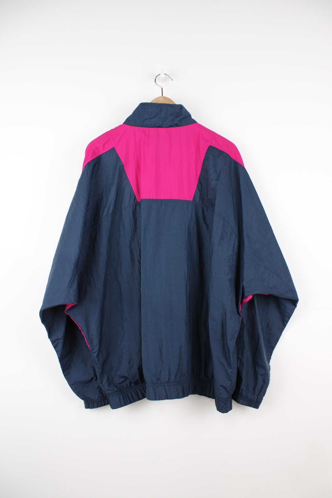 Vintage Umbro Pullover Windbreaker in a navy blue and pink colourway, half zip, side pockets, and has the logo embroidered on the front.