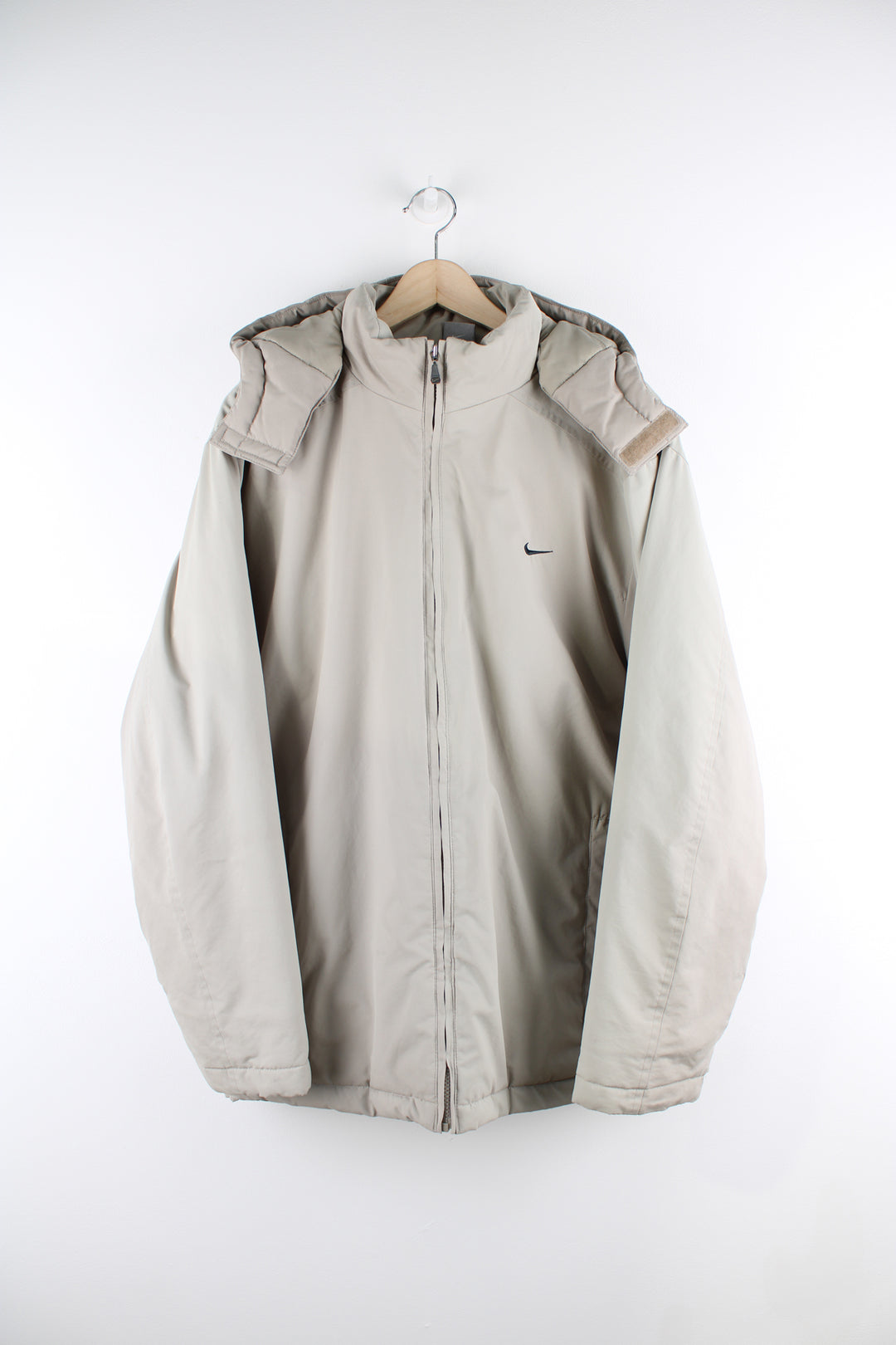 Vintage Nike outdoors jacket in a tan colourway, zip up, side pockets, detachable hood, insulated with a quilted lining, and has swoosh logo embroidered on the front and back.