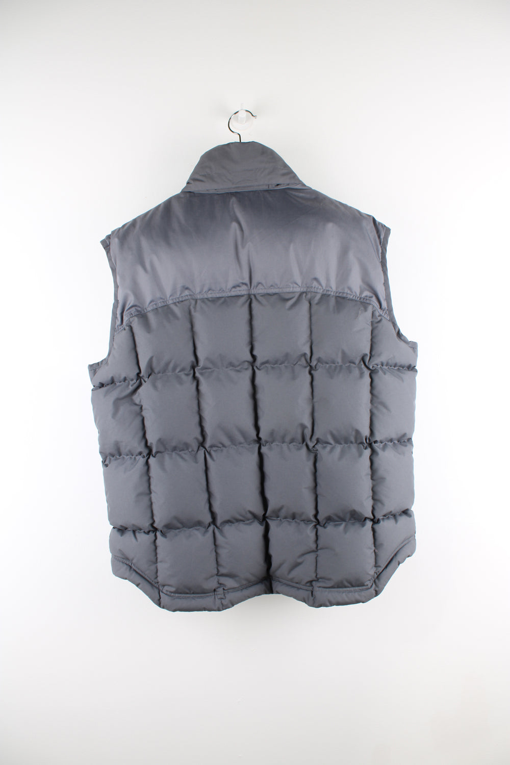 Vintage Nike padded gilet in grey, zip up, insulated, hidden hood, and has swoosh logo embroidered on the front. 